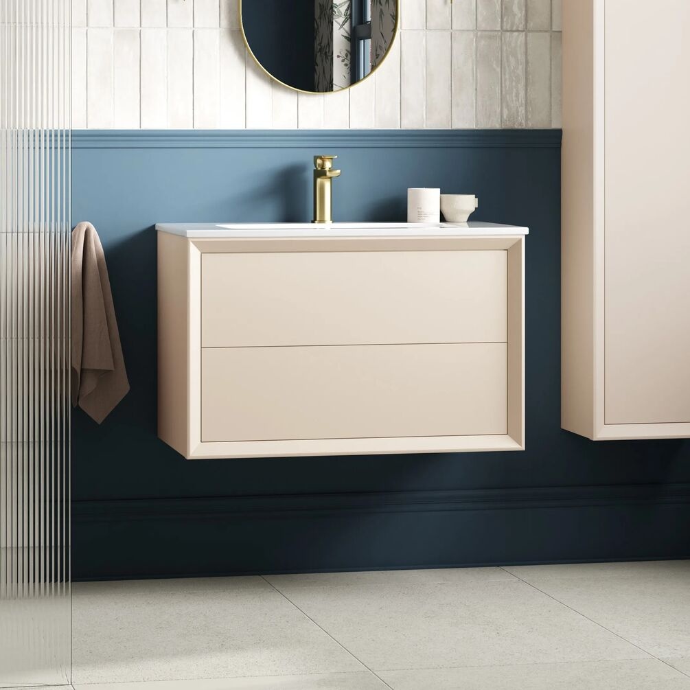Product lifestyle image of Apex Air Matt Cotton 815mm 2 Drawer Wall Hung Unit and Basin against blue wall with brass tap ZERO108466